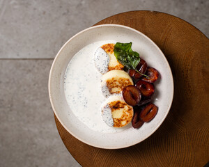 Cottage cheese pancakes, caramel cream sauce with poppy seeds and basil, fresh caramelized plums ( syrniki )