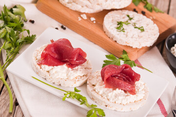 Rice cakes with milk flakes and cold beef.