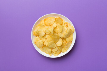 Potato chips on bowl isolated on colored background. Delicious crispy potato chips in bowl. Space for text. Top view
