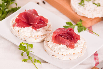 Rice cakes with milk flakes and cold beef.