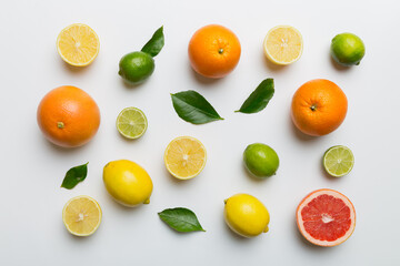 Flat lay of citrus fruits like lime, orange and lemon with lemon tree leaves on light colored background. Space for text healthy concept. Top view