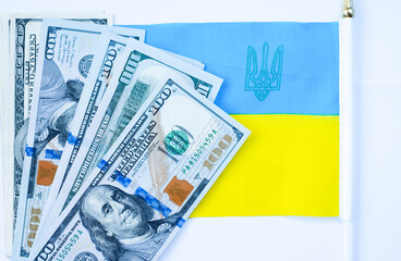 dollars against the background of the Ukrainian flag. The war in Ukraine, financial assistance from the whole world