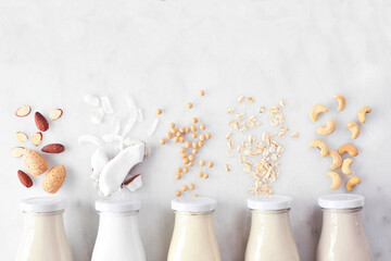 Vegan, plant based, non dairy milk. Variety in milk bottles with ingredients. Above view over a...