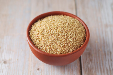 Dry couscous in a small ceramic bowl	