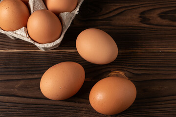 Happy Easter. Easter eggs. Chicken brown eggs closeup top view On the table. A carton crate of fresh brown eggs. Organic chicken eggs in a egg carton.