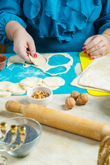 A Jewish woman makes dough blanks Gomentashi cookies with poppy seeds, traditional for the Jewish holiday Purim.