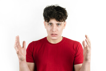 Naklejka premium Embarrassed, depressed, the teenager raised his hands and seemed to ask - How? Why? Sad teenager guy with misunderstanding of the situation