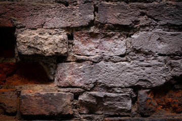 Old, black brick wall torn