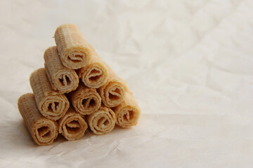 cookies on a plate, a mountain of waffle tubes on parchment paper,