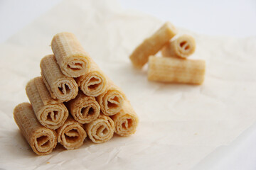 cookies on a plate, a mountain of waffle tubes on parchment paper,