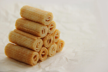 cookies on a plate, A mountain of waffle tubes on parchment paper