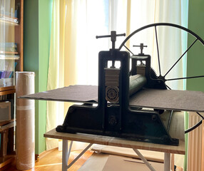 Old ancient engraving machine. Etching press for printmaking. Art equipment in studio..Space for...