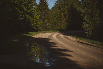 Obraz premium winding sand and gravel road in spring season in Latvia