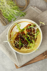 A traditional Hungarian dish is bograch or thick meat red goulash with lentil puree, served in eco paper bowl on a gray background. Restaurant food delivery service and daily ration concept.