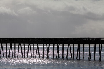 Moody picture of the silhouette of a pier on a cloudy day