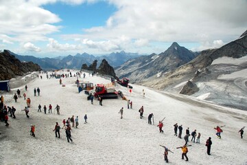 Hintertuxer Gletscher mit Skipiste Skifahrern Gipfelstation Seilbahn Pistenbully und gefrorene Wand