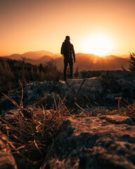 Person on Mountain Peak during Sunset on a warm summer Day