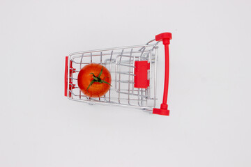 Tomatoes in metal basket on white background
