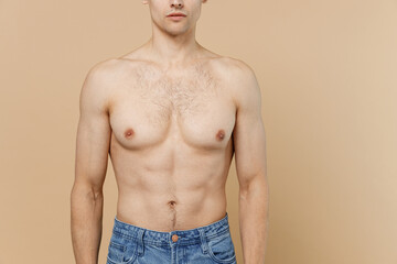 Young caucasian european man 20s wear jeans pants with naked torso isolated on pastel pastel beige...