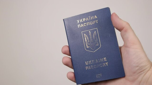 Blue passport of Ukraine male hand holding a document. The concept of tourism, travel, air travel, nationality