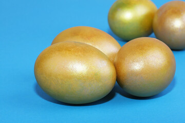 Golden Easter eggs on a blue background. Easter background