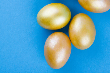 Golden Easter eggs on a blue background. Easter background