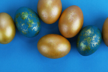 Golden Easter eggs on a blue background. Easter background