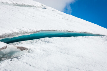 Long, gorgeous icy-blue crack or crevasse in glacier