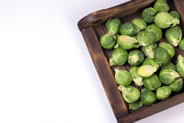 Wooden box full Fresh organic Brussels sprouts on white background.