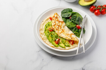 Omelet with vegetables, avocado and cherry tomatoes. Omelette. Copy space
