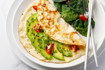 Stuffed Omelet with vegetables, avocado and cherry tomatoes. Spinach Top view.