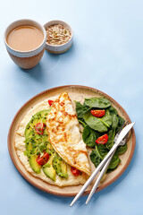 Sunny Breakfast with coffee and omlette. Omlet with avocado and tomatoes.