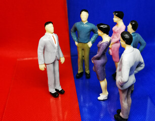 Danish politics symbolised by figurines debating in a blue and a red area where the politicians...