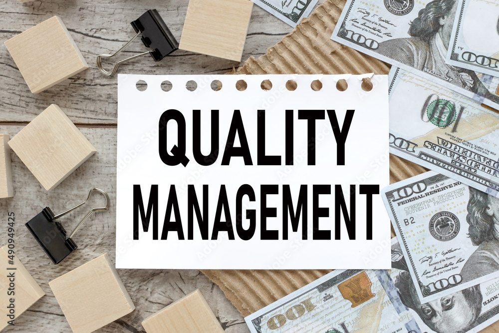 Poster wooden background with an open notepad next to wooden cubes and banknotes. quality management.