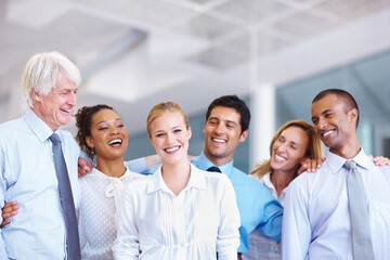 We are together. Portrait of young business woman smiling with her group at office.