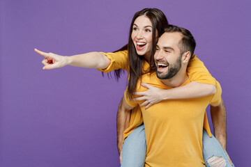 Young fun amazed couple two friends family man woman together in yellow casual clothes giving...
