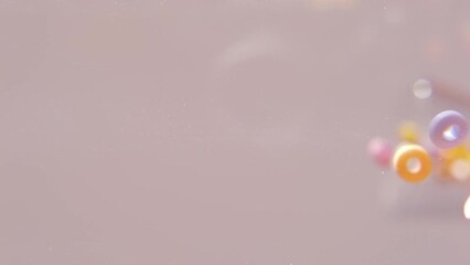 many colored sweets, pink, red, orange, yellow round candies bounce with rings, beads falls down, bounce, concept of children's health, vitamins, joy of childhood, slow motion - Powered by Adobe