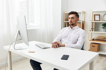 handsome man sitting at a desk in front of a computer with a keyboard technologies