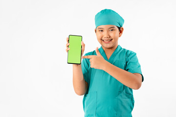 Portrait of Young Asian Boy Dressing to be Doctor, Holding Smart phone with Green Screen Isolate on White Background, Education and Technology Concept