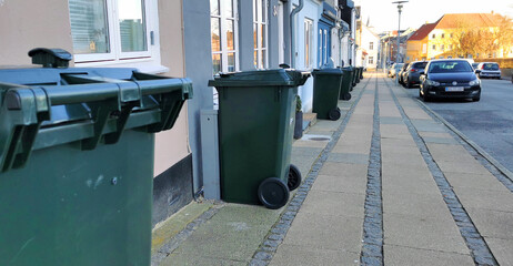 Fototapeta na wymiar Row of trash bins outside houses in a Danish city