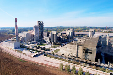 Industrial plant, aerial view. Cement plant with pipes on cement production. Factory with smoke...