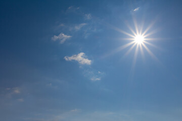 Naklejka na ściany i meble bright blue cloudy sky with sparkle sun, natural sky background