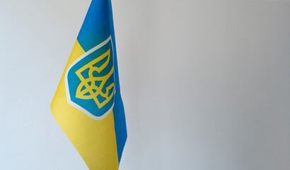Close up copy space mockup of Ukrainian flag with trident on white background.