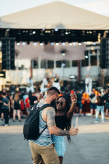 Beautiful couple drinking cocktails and having fun at music festival