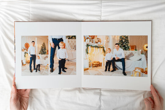 hands with opened photobook on a white background. family photo shoot 