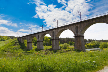 Viaduct. Beautiful old arched stone railway bridge against the backdrop of a scenic landscape