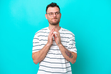 Young Brazilian man isolated on blue background scheming something