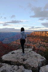 Obraz premium Woman staring at Grand Canyon during sunset, Arizona, United States