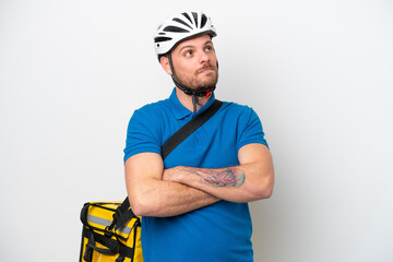 Young brazilian man with thermal backpack isolated on white background looking up while smiling