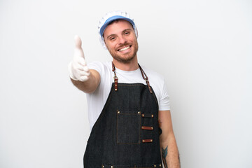 Fishmonger man wearing an apron isolated on white background shaking hands for closing a good deal